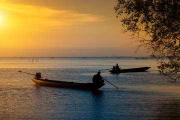 Fototapeta na wymiar Silhouette fisherman and Sunset sky on the lake.