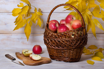 Корзина с яблоками на деревянном фоне