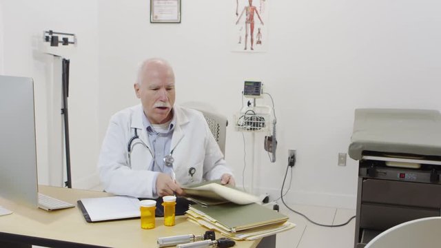 Elderly doctor writing perscriptions and notes