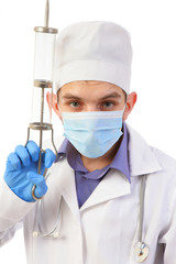 Portrait of the doctor in a mask with the big syringe isolated on a white background