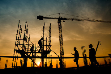 silhouette the group of workers working at a construction site.Construction workers work in...