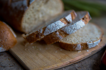 Bread slice on a wooden board. Wheat fresh loaf