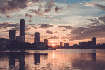 Naklejka premium Yekaterinburg city center on sunset. City pond view, amazing clouds and sky. High buildings, skyscrapers on the embankment of the river Iset