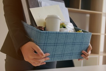 Business woman moving offices packing up Cardboard Box in office.