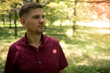 Young attractive man in the park in summer. Portrait of man