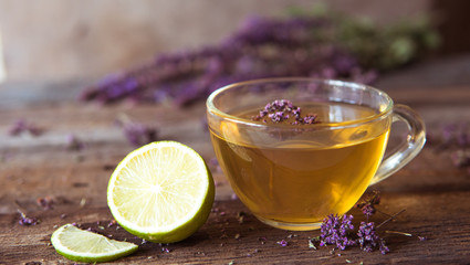 Green tea with herbals and lime. Tea with oregano on the wooden background