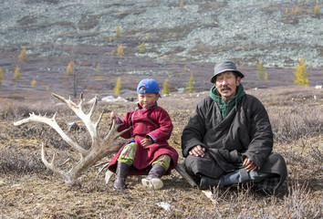 tsaatan nomadic boy and his grandfather in a traditional deels resting