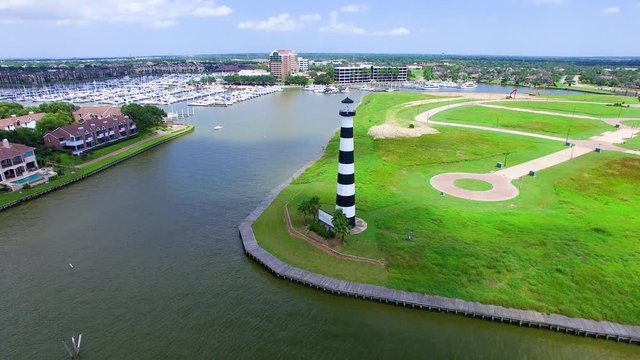 Black and White lighthouse on a lake next to a boat marina takin from a drone
