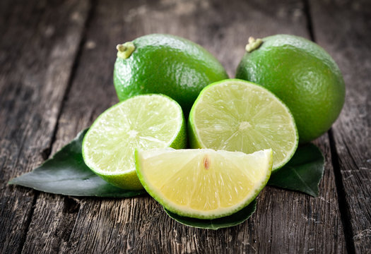 Fresh ripe limes on wooden background.