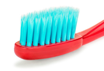Красная зубная щетка с бирюзовыми щетинками крупным планом на изолированном белом фоне