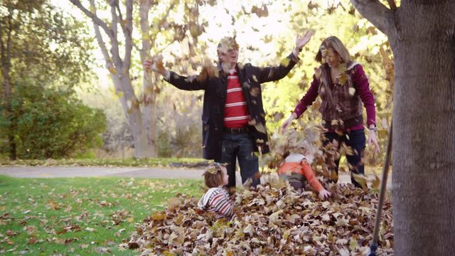 Family throwing a bunch of autumn leaves