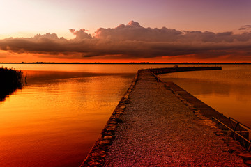 Fototapeta na wymiar Sunset over calm lake. Colorful and vibrant landscape of lake