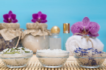 three plates with sea salt, against the background of purple orchids SPA