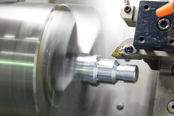 CNC lathe machine (Turning machine) cutting the metal  screw thread part by lathe cutter .Hi-precision CNC machining concept.