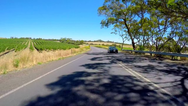 Vehicle POV driving along highway through the Barossa Valley, winery region of South Australia.