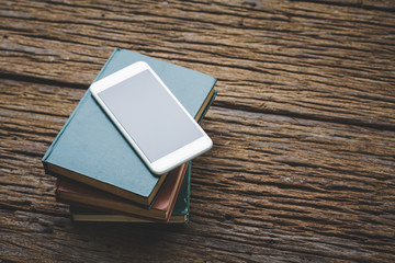 Book with smartphone on wood vintage tone
