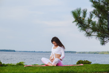 Fototapeta na wymiar Meditating pregnant woman outdoors. 