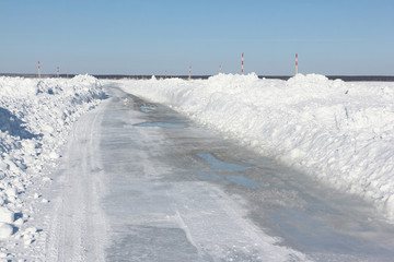 Ice road melting on a frozen reservoir in winter, Ob river, Siberia, Russia