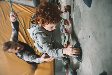 Little boy climbing wall at gym © LIGHTFIELD STUDIOS