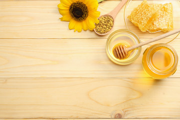 Sunflower with honey, Honeycomb and honey dipper on light wooden table. Top view with copy space