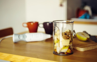 Beaker for blending fruit in a blender: smoothies of nuts, banana, pear, peach. Healthy eating and a delicious Breakfast.