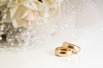 Obraz na płótnie Canvas Wedding rings and bridal bouquet on a light background.