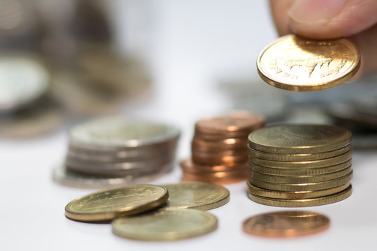 Hand put coins to stack of coins. Concept of money saving and financial. Selective focus.
