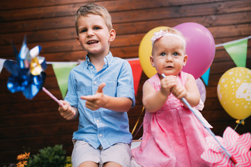 Happy young boy and little girl at birthday party