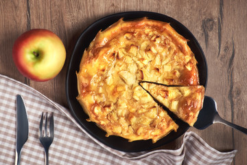 Homemade apple pie with apple and  napkin on wooden table