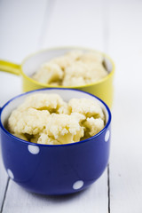 Boiled cauliflower in multi-colored bowls