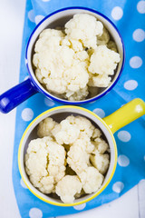 Boiled cauliflower in multi-colored bowls