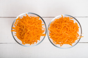 Grate  carrots in a bowl