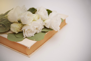 White lisianthus flower bouquet with old book