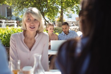 Friends using laptop in restaurant