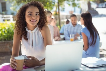 Beautiful woman holding coffee cup and mobile phone