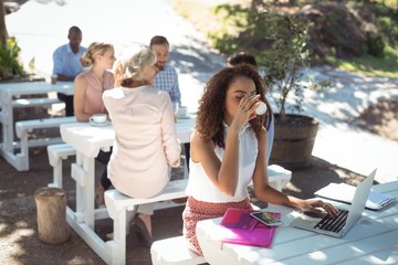 Beautiful woman using laptop while having coffee