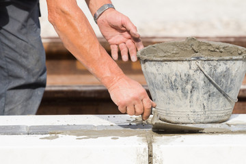 Construction worker working hard and leveling concrete pavement outdoors.