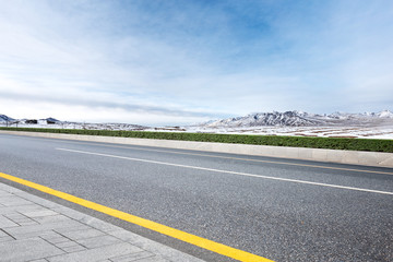 Fototapeta na wymiar empty asphalt road with beautiful snow mountains