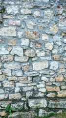 Stone old wall from huge blocks. Background of stones. The concept of reliability. The space between stones is filled with cement.