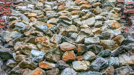 Stone old wall from huge blocks. Background of stones. The concept of reliability. The space between the stones is filled with cement.