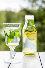 en glas flaska med detox vatten och ett glas