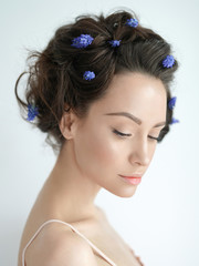 Beautiful young woman with blue muscari in her hair