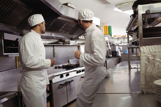 Chefs interacting with each other in kitchen