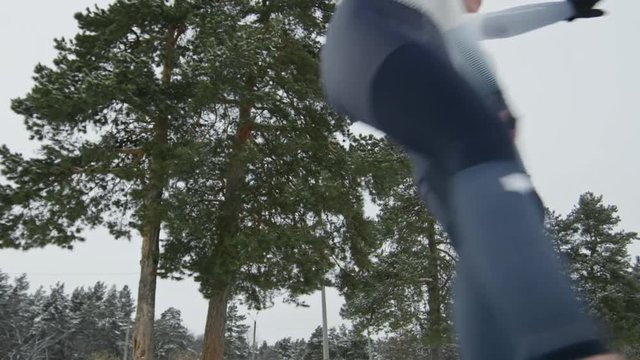 Low angle of female speed skaters in professional sportswear skating before camera and high fiving each other