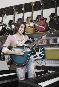 girl choosing acoustic guitar