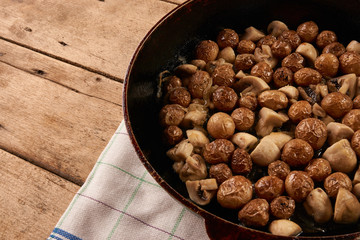 Fried potatoes and mushrooms in frying pan