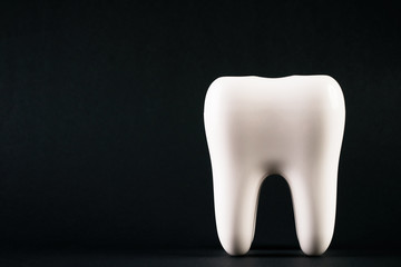 White healthy human tooth isolated on a black