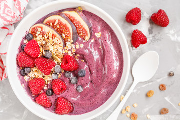 Smoothie bowl (blueberry, acai) with figs, raspberries and granola.