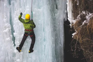 Fototapeten The climber climbs on ice. © zhukovvvlad