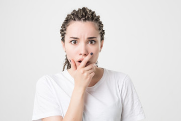 Fototapeta na wymiar Confused young female posing isolated at white wall